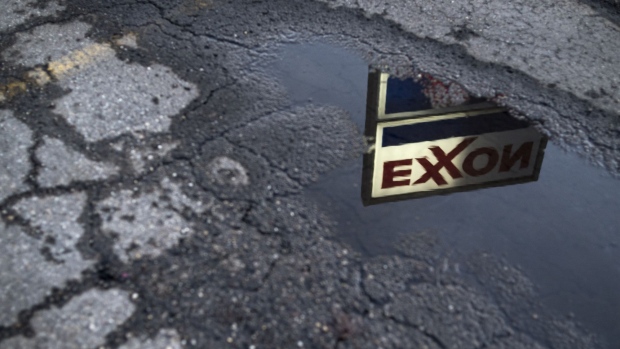 Exxon Mobil Corp. signage is reflected in a puddle at a gas station in Nashport, Ohio, U.S., on Friday, Jan. 26, 2018. Exxon Mobil Corp. is scheduled to release earnings figures on February 2. 