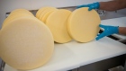 An employee puts a cheese wheel on a counter at a facility in California. Bloomberg