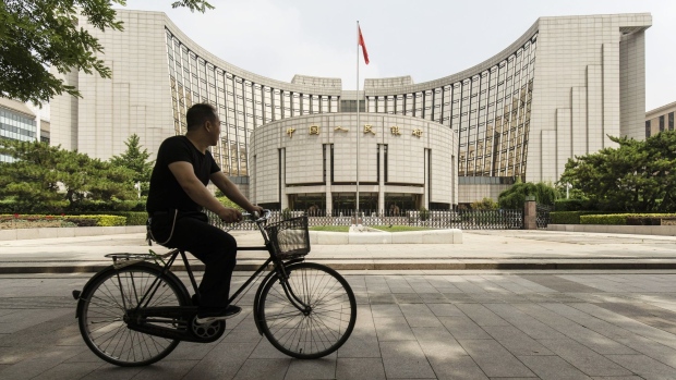 A man rides a bicycle past the People's Bank of China (PBOC) headquarters in Beijing, China, on Friday, June 7, 2019. China's central bank governor said there's "tremendous" room to adjust monetary policy if the trade war deepens, joining counterparts in Europe and the U.S. in displaying readiness to act to support the economy. 
