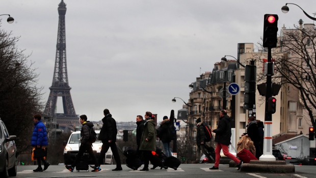 Commuters cross a street during the 23rd day of transport strikes in Paris, Dec. 27, 2019. AP Photo