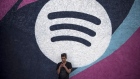 An attendee checks his mobile handset in front of Spotify House during the South By Southwest (SXSW) Interactive Festival at the Austin Convention Center in Austin, Texas, U.S., on Monday, March 14, 2016. 