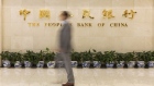 A man walks past signage at the lobby of the People's Bank of China (PBOC) headquarters in Beijing, China, on Friday, June 7, 2019. China's central bank governor said there's "tremendous" room to adjust monetary policy if the trade war deepens, joining counterparts in Europe and the U.S. in displaying readiness to act to support the economy. 
