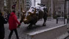 Pedestrians walk past the Charging Bull sculpture stands in New York, Jan. 25, 2019. Bloomberg