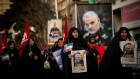 Mourners carry images of Iranian General Qassem Soleimani during a funeral ceremony in Tehran, on Jan. 6. 