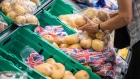 A customer picks a bag of potatoes inside a Morrisons supermarket, operated by Wm Morrison Supermarkets Plc, in London, U.K., on Wednesday, Aug. 8, 2018. Morrisons reported a growth in profits in their most recent financial year, boosted by food price inflation. 