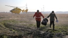 Rescue workers carry items retrieved from the scene where a Ukrainian plane crashed in Shahedshahr