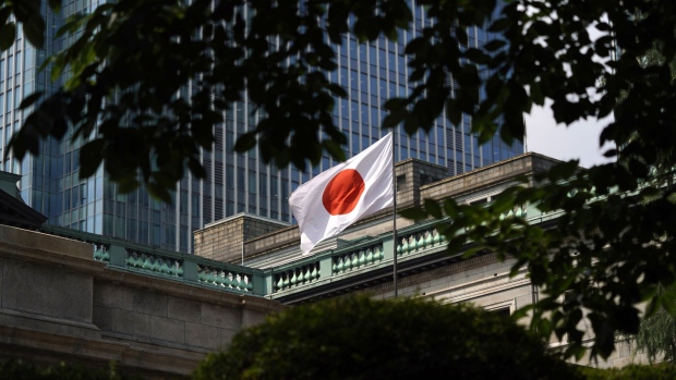 A Japanese national flag flies outside the Bank of Japan (BOJ) headquarters in Tokyo, Japan, on Thursday, June 20, 2019. The BOJ kept monetary policy unchanged, just hours after the Federal Reserve became the latest central bank to signal a willingness to cut interest rates in the face of rising threats to global growth. Photographer: Toru Hanai/Bloomberg