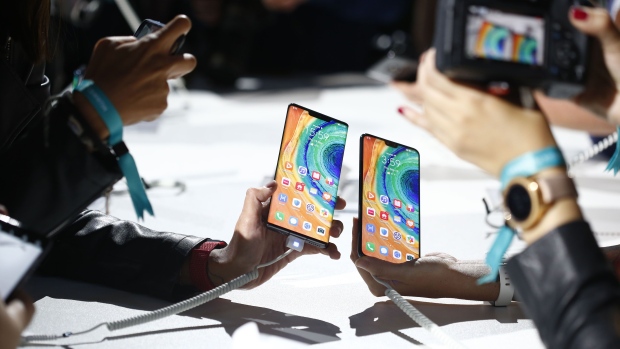 Attendees take photographs of the new Huawei Technologies Co. Mate 30 smartphones during the device's unveiling in Munich, Germany, on Thursday, Sept. 19, 2019. The Huawei Mate 30 and Mate 30 Pro mark the brand’s first top-of-the-range device launch since it was forbidden in the spring from trading with American partners. Photographer: Michaela Handrek-Rehle/Bloomberg