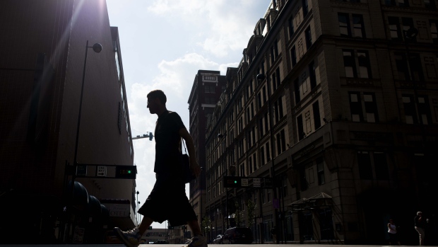People walk through the streets of downtown Cincinnati, Ohio, U.S., on Tuesday, Aug. 19, 2014. The U.S. economy will expand 3 percent in the third quarter, according to the latest results of a Bloomberg News survey of 76 economists. Photographer: Ty Wright