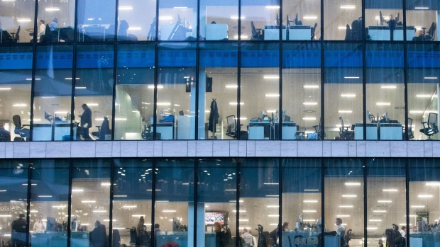 Office workers sit inside an illuminated office building in London, U.K., on Thursday, Nov. 22, 2018. Brexit Britain will be the top destination for major European investors to snap up commercial property next year, according to a survey of executives managing more than 500 billion pounds ($640 billion) of real estate conducted by Knight Frank. Photographer: Chris Ratcliffe/Bloomberg
