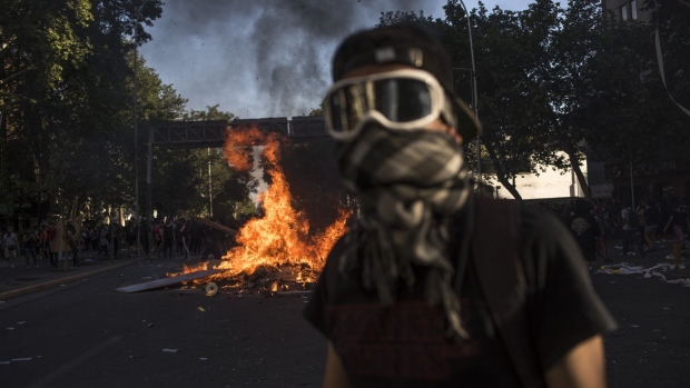 Fire burns on a street during a protest in Santiago, Chile, on Monday, Oct. 21, 2019.