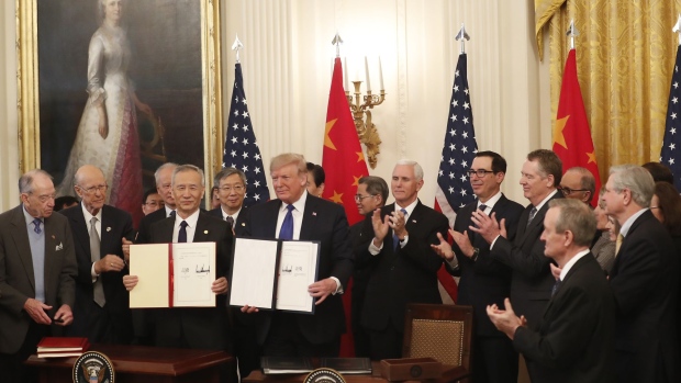 Donald Trump, center, and Liu He, left, display the signed U.S.-China "phase-one" trade agreement during a ceremony in Washington on Jan. 15. Photographer: Zach Gibson/Bloomberg