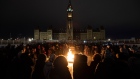 Several hundred people gather around the Centennial flame for a candle light vigil to remember those
