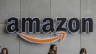 Employees stand near an The Amazon Inc. logo is displayed above the reception counter at the company's campus in Hyderabad, India, on Friday, Sept. 6, 2019. Amazon's only company-owned campus outside the U.S. opened at the end of August on the other side of the globe, thousands of miles from their Seattle headquarters. The 15-storey building towers over the landscape in Hyderabad's technology and financial district, signaling the giant online retailer's ambitions to expand in one of the world's fastest-growing retail markets. Photographer: Dhiraj Singh/Bloomberg