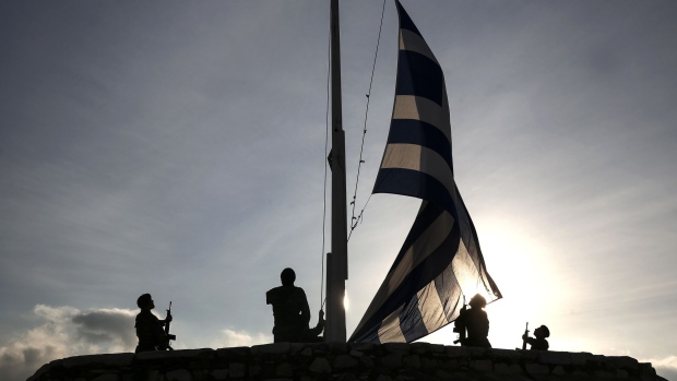 Greek army soldiers raise the national flag early morning on Acropolis Hill in Athens, Greece, on Thursday, Feb. 9, 2017. Greece is back in the headlines as it struggles to free itself from a disagreement between the International Monetary Fund and Europe. Photographer: Yorgos Karahalis/Bloomberg