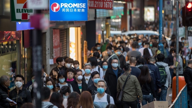 People wearing masks walk on a street in Kwun Tong district of Hong Kong, China, on Thursday, Jan. 23, 2020. A deadly coronavirus, which first appeared last month in the city of Wuhan in central China, has spread from the mainland to locations from Hong Kong to the U.S., coloring what is usually a period of celebration and reunion for Chinese people across the world with tension and anxiety. Photographer: Paul Yeung/Bloomberg