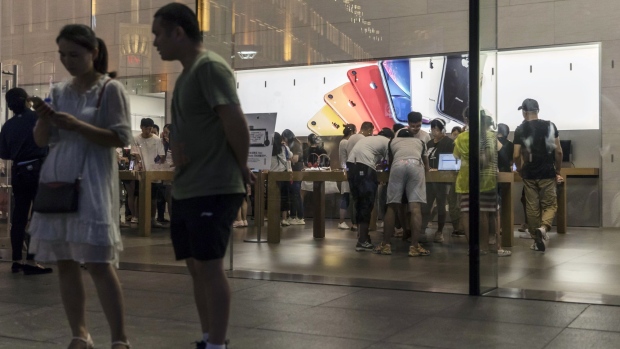 Pedestrians stand outside an Apple Inc. store in Shanghai. Photographer: Qilai Shen/Bloomberg