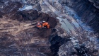 An excavator is seen at the Suncor Energy Inc. Millennium mine in this aerial photograph taken above the Athabasca oil sands near Fort McMurray, Alberta, Canada, on Monday, Sept. 10, 2018. While the upfront spending on a mine tends to be costlier than developing more common oil-sands wells, their decades-long lifespans can make them lucrative in the future for companies willing to wait. 