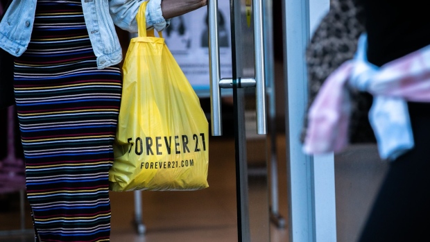 A customer carries a Forever 21 Inc. shopping bag while exiting a store in the Union Square neighborhood of New York, U.S., on Thursday, Aug. 29, 2019. Forever 21 Inc. is preparing for a potential bankruptcy filing as the fashion retailers cash dwindles and turnaround options fade, according to people with knowledge of the plans. Photographer: Jeenah Moon/Bloomberg