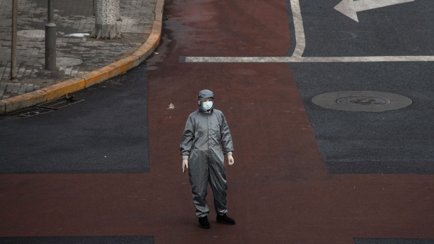 BEIJING, CHINA - FEBRUARY 08: A Chinese woman wears a protective suit and mask as she waits to cross the intersection of a nearly empty street on February 8, 2020 in Beijing, China. The number of cases of a deadly new coronavirus rose to more than 34000 in mainland China Saturday, days after the World Health Organization (WHO) declared the outbreak a global public health emergency. China continued to lock down the city of Wuhan in an effort to contain the spread of the pneumonia-like disease which medicals experts have confirmed can be passed from human to human. In an unprecedented move, Chinese authorities have put travel restrictions on the city which is the epicentre of the virus and municipalities in other parts of the country affecting tens of millions of people. The number of those who have died from the virus in China climbed to over 724 on Saturday, mostly in Hubei province, and cases have been reported in other countries including the United States, Canada, Australia, Japan, South Korea, India, the United Kingdom, Germany, France and several others. The World Health Organization has warned all governments to be on alert and screening has been stepped up at airports around the world. Some countries, including the United States, have put restrictions on Chinese travellers entering and advised their citizens against travel to China. (Photo by Kevin Frayer/Getty Images)