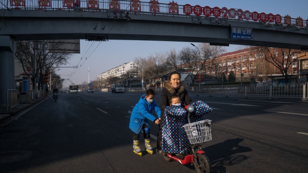 A family of three travel along an empty street in Beijing, Feb. 10.