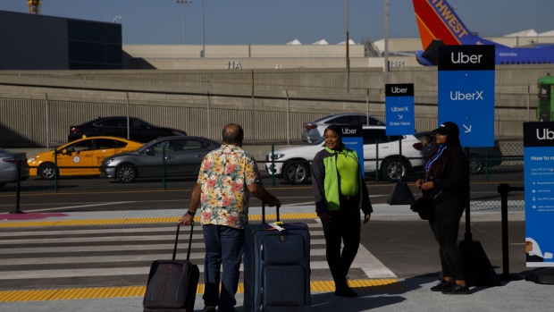 A passenger waits for an Uber Technologies Inc. vehicle at the LAX-it centralized pickup area at Los Angeles International Airport (LAX) in Los Angeles, California, U.S., on Tuesday, Oct. 29, 2019. On Tuesday, Los Angeles International Airport's ban on Uber, Lyft, and taxi curbside pickup went into effect while the airport ramps up work on its modernization program. Photographer: Patrick T. Fallon/Bloomberg