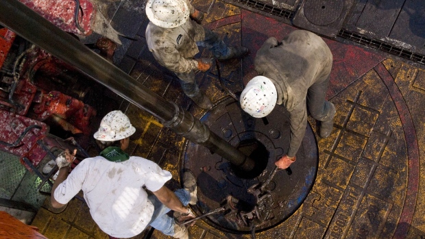 Patterson UTI Drilling Co. floorhands move a drill pipe collar as pipe is removed from a natural gas well being drilled in the Eagle Ford shale in Karnes County, Texas, U.S.