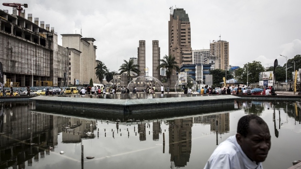 People sit around a disused fountain in the business district of Kinshasa, Democratic Republic of the Congo, on Friday, Jan. 11, 2019.