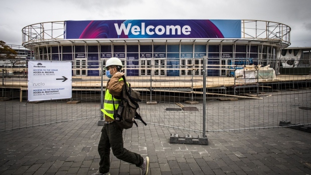 A worker wearing a protective face mask walks past the entrance to the venue for the Mobile World Congress in Barcelona, Spain, on Feb. 12. Photographer: Angel Garcia/Bloomberg