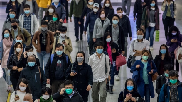 Pedestrians wearing protective masks walk along a street in the Central district of Hong Kong, China, on Tuesday, Feb. 11, 2020. Hong Kong stocks closed just below a key technical level on Tuesday, a sign investors are still assessing the fallout of the deadly coronavirus outbreak. 