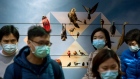 Pedestrians wearing protective masks walk past the HSBC Holdings Plc logo displayed on a hoarding in Hong Kong, China, on Friday, Jan. 31, 2020. The U.S. and Japanese governments advised their citizens to avoid travel to China as the spread of the coronavirus showed few signs of abating. Photographer: Paul Yeung/Bloomberg