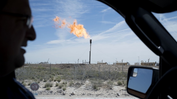 A gas flare is seen through a car window as a Royal Dutch Shell Plc representative drives near Mentone, Texas. Photographer: Matthew Busch/Bloomberg
