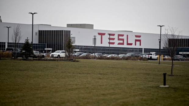 Vehicles sit parked outside the Tesla Inc. solar panel factory in Buffalo, New York. Photographer: Andrew Harrer/Bloomberg