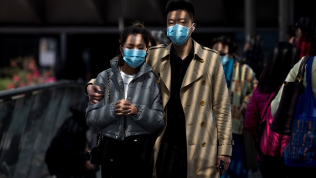 Pedestrians wearing protective masks walk across a footbridge in the Central district of Hong Kong, China, on Wednesday, Jan. 29, 2020. Governments tightened international travel and border crossings with China as they ramped up efforts to stop the spread of the disease. Photographer: Paul Yeung/Bloomberg