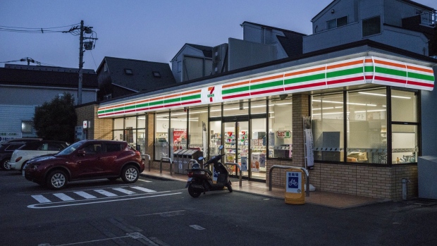 Vehicles and a motorbike are seen in front of a 7-Eleven convenience store, operated by Seven & i Holdings Co., in Tokyo, Japan, on Monday, June 17, 2019. The Japan Franchise Association will release sales figures on nationwide convenience stores on June 20. Photographer: James Whitlow Delano/Bloomberg
