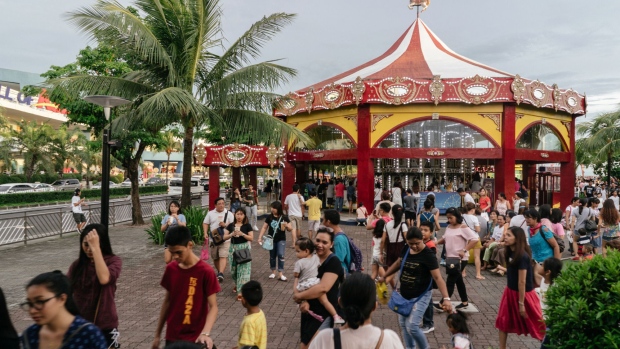 Visitors attend the SM by the Bay amusement park in the SM Mall of Asia complex, operated by SM Prime Holdings Inc., in Pasay City, Metro Manila, the Philippines, on Sunday, Aug. 5, 2018. Consumer prices in the Philippines increased at the fastest pace in more than five years in July, boosting the case for the third interest-rate hike this week. Photographer: Hannah Reyes Morales/Bloomberg