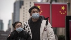 Pedestrians wearing protective masks walk past Chinese flags displayed on Nanjing East Road ahead of the Lunar New Year in Shanghai, China, on Thursday, Jan. 23, 2020. A deadly coronavirus, which first appeared last month in the city of Wuhan in central China, has spread from the mainland to locations from Hong Kong to the U.S., coloring what is usually a period of celebration and reunion for Chinese people across the world with tension and anxiety.