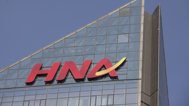 Signage for HNA Group Co. is displayed atop the company's building in Beijing, China, on Thursday, Feb. 1, 2018. Companies linked to HNA have secured 7.8 billion yuan ($1.2 billion) in long-term loans from Chinese banks to finance an expansion project in Meilan Airport in HNA's home province of Hainan. Photographer: Giulia Marchi/Bloomberg