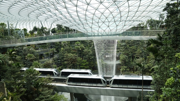 Skytrains sit on an elevated platform in front of the Rain Vortex in the Forest Valley garden during a media tour of the Jewel Changi Airport in Singapore, on Thursday, April 11, 2019. The Jewel is a new mega-attraction at Singapore's Changi Airport and will open its doors to the public on April 17. Photographer: Wei Leng Tay/Bloomberg
