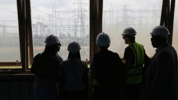 Visitors look at electricity pylons carrying power lines at the newly renovated energy generation plant, operated by Egbin Power Plc, in Lagos, Nigeria, on Wednesday, Aug. 26, 2015. While Nigeria was the world's fourth-biggest exporter of liquefied natural gas in 2012, it's struggling to meet local demand for the fuel used by plants that generate at least 70 percent of the country's electricity needs. Photographer: Bloomberg/Bloomberg