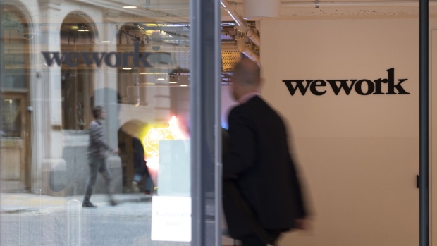 A visitor walks through the entrance to the WeWork co-working office space, operated by the parent company We Co., on Eastcheap in London, U.K., on Monday, Oct. 7, 2019. While WeWork has been rapidly expanding in Canada, the New York-based company is facing challenges on multiple fronts with Landlords in London and New York the most exposed to any further deterioration at the co-working firm. Photographer: Bryn Colton/Bloomberg