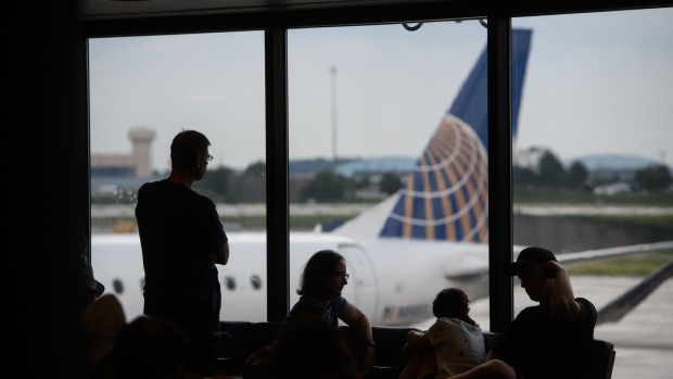 People watch as a United Airlines Holdings Inc. plane arrives at a gate at the Pittsburgh International Airport (PIT) in Moon Township, Pennsylvania, U.S., on Tuesday, July 2, 2019. Programs adopted or being considered by a number of airports allow people beyond security checkpoints so they can meet arriving relatives or just hang out as airports expand options to fill passenger dwell time. Photographer: Justin Merriman/Bloomberg
