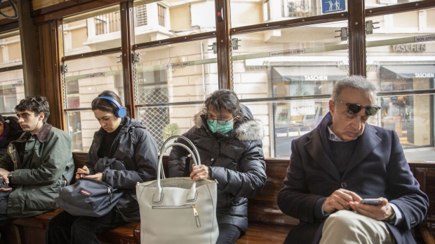 A commuter wearing a protective face mask rides the tram in Milan, Italy, on Monday, Feb. 24, 2020. Stunned by Europe's biggest surge of the coronavirus, Italy appears to be operating in near panic mode. Photographer: Francesca Volpi/Bloomberg