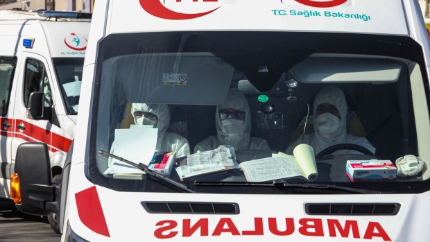 Health personnel wearing protective gear ride in an ambulance carrying passengers and crew of a Turkish Airlines plane from Tehran as they are taken to Dr. Zekai Tahir Burak Hospital for a 14-day quarantine and to be tested for possible coronavirus infection on February 25, 2020 in Ankara, Turkey. 
