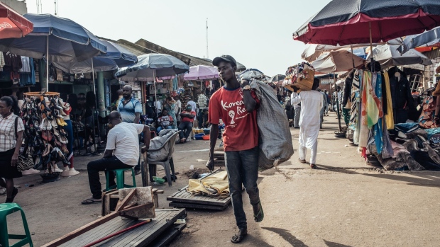 Pedestrians walk through the Wuse market in Abuja, Nigeria, on Friday, Jan. 10, 2020. Revenue in Nigeria has fallen short of the government target by at least 45% every year since 2015, and shortfalls have been funded through increased borrowing. Photographer: KC Nwakalor/Bloomberg