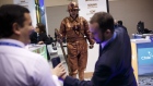 Attendees take a photograph of a man dressed as a copper miner statue at the Chilean Ministry of Mining booth during the 2017 Prospectors & Developers Association of Canada (PDAC) convention in Toronto, Ontario, Canada, on Tuesday, March 7, 2017. The prospect of increased deal-making is set to be a hot topic for the more than 20,000 geologists, promoters and investors expected to attend the four-day PDAC convention, the world's biggest mining gathering. 