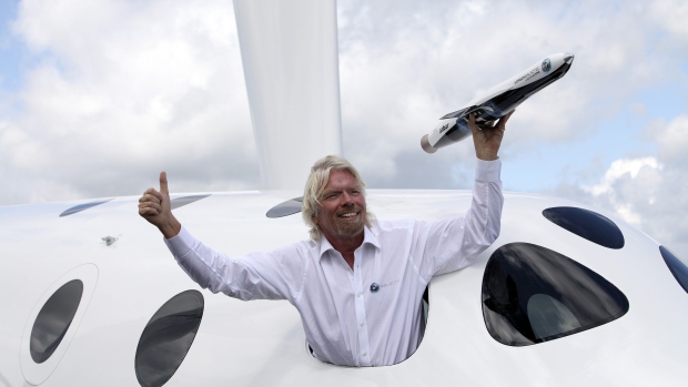 Richard Branson, poses for photographers with a model of the LauncherOne rocket, from the window of Virgin Galactic's SpaceShipTwo, on the third day of the Farnborough International Air Show in Farnborough, U.K., on Wednesday, July 11, 2012. The Farnborough International Air Show runs from July 9-15. Photo: Bloomberg Photographer: Bloomberg/Bloomberg