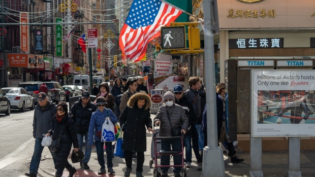 A person wearing a protective mask waits to cross a street in the Chinatown neighborhood of New York, U.S., on Thursday, Feb. 27, 2020. U.S. President Donald Trump announced Wednesday that Vice President Mike Pence would lead the administration's response to the coronavirus, which has now spread to more than 80,000 people worldwide and sparked a major sell-off on Wall Street. Photographer: David Dee Delgado/Bloomberg