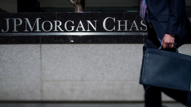 A man carrying a briefcase walks past the JPMorgan Chase & Co. headquarters in New York. Photographer: Ron Antonelli/Bloomberg