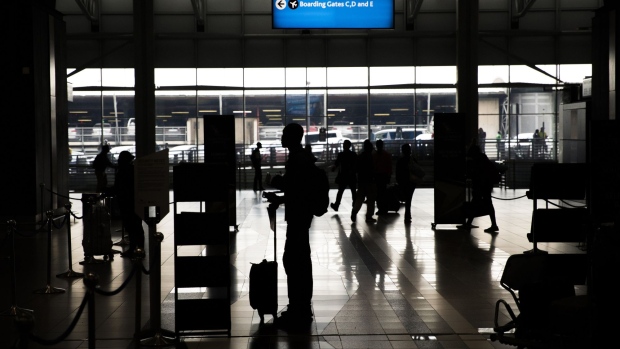 Passenger pass through the departures hall at O.R. Tambo International Airport in Johannesburg. Photographer: Guillem Sartorio/Bloomberg